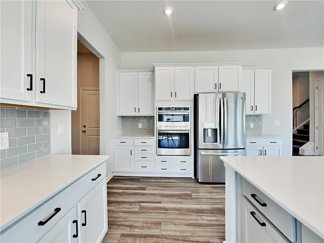 a kitchen with stainless steel appliances a refrigerator and a stove top oven