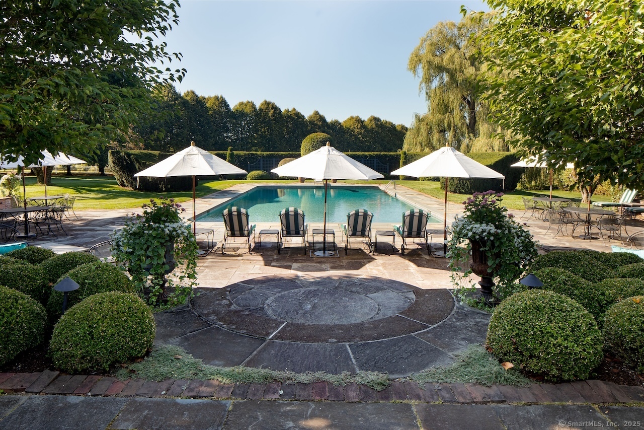 406 Wells Hill Road Salisbury, CT 06039 - Photo 14 of 38 a view of a patio with chairs and a umbrella