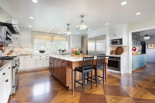 a kitchen with stainless steel appliances kitchen island granite countertop a stove a sink a oven and a refrigerator