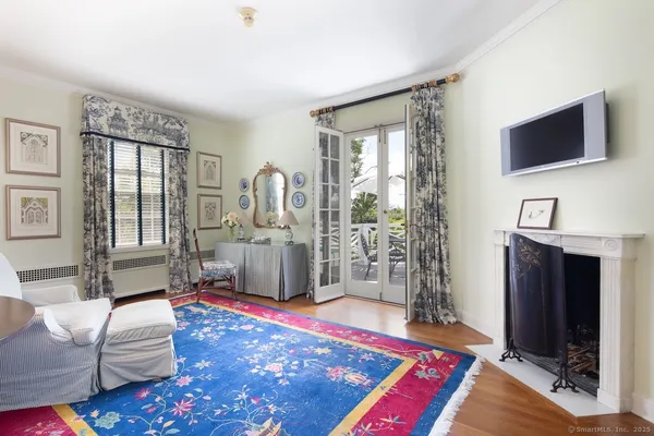 a living room with furniture a flat screen tv and a rug