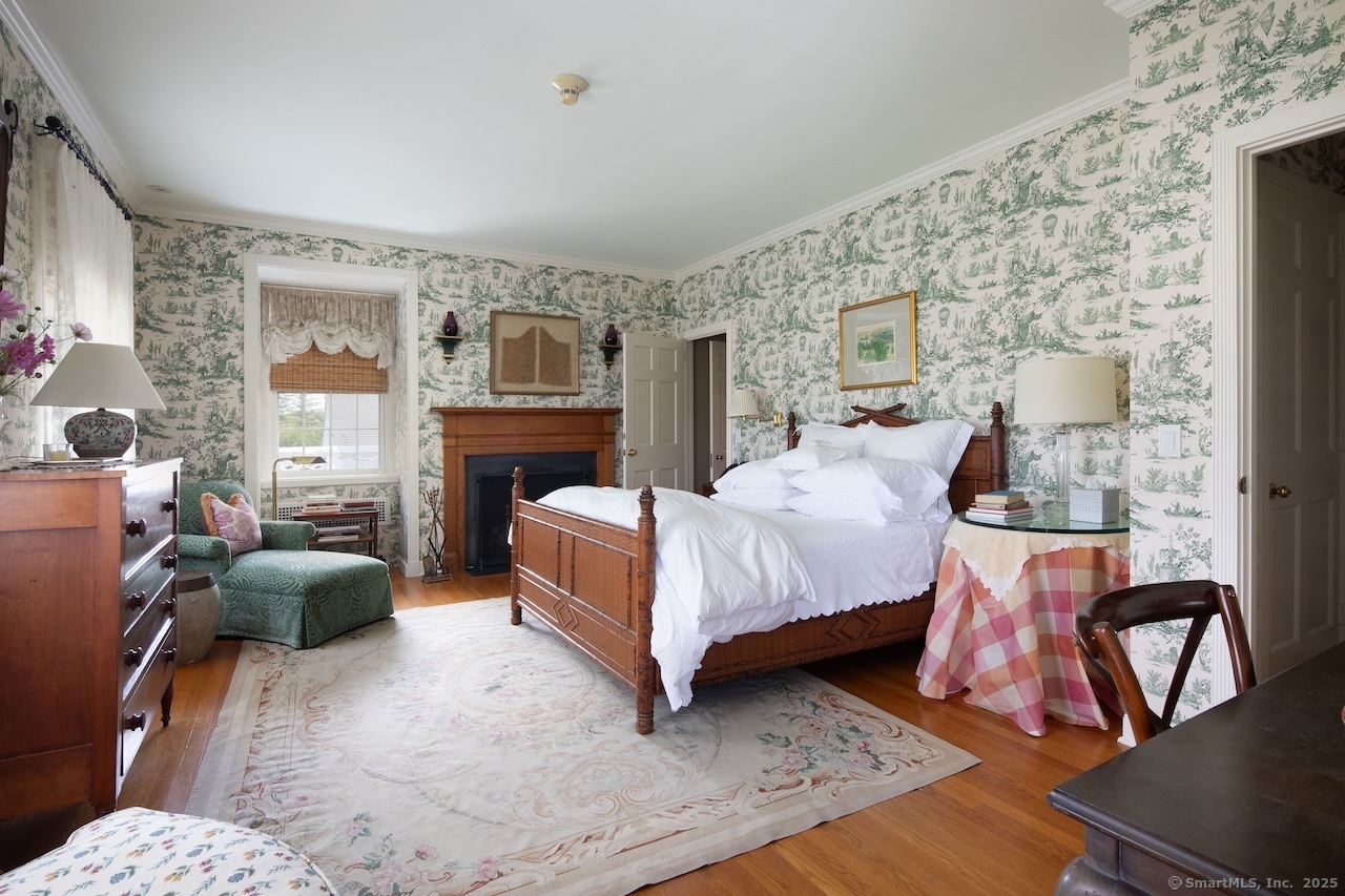 406 Wells Hill Road Salisbury, CT 06039 - Photo 30 of 38 a bedroom with a bed wooden floor and a fireplace