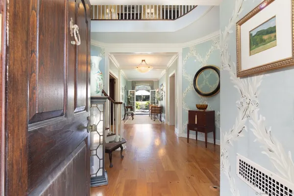 a view of a hallway with wooden floor and a bookshelf