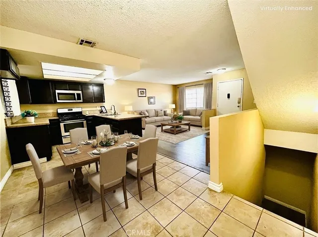 a dining hall with stainless steel appliances a stove a sink a dining table and chairs