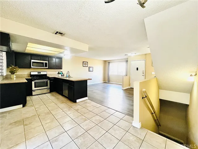 a kitchen with stainless steel appliances a sink a stove top oven a counter space and cabinets