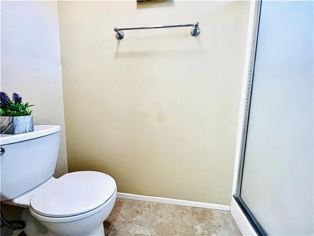 a white toilet sitting next to a shower
