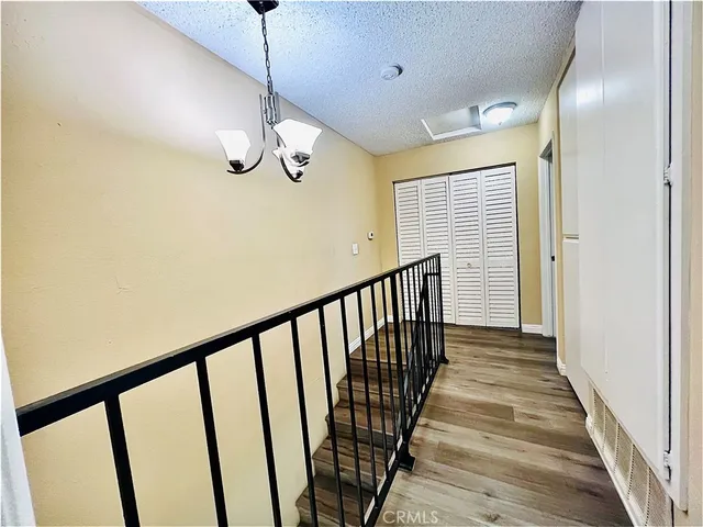 a view of a hallway with wooden floor and staircase