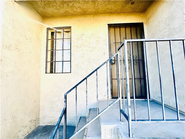 a view of staircase with lots of frames on wall and a window