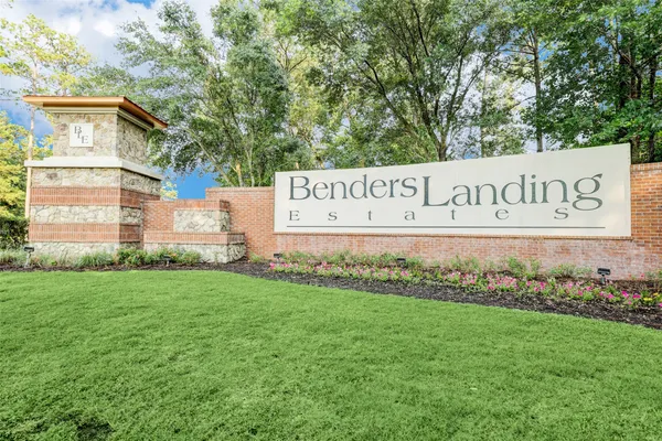 a sign of golf club on a wall under a tree
