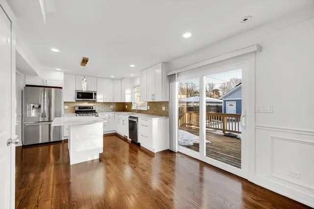 a kitchen with a refrigerator and white cabinets