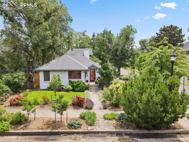 a front view of a house with a yard and potted plants