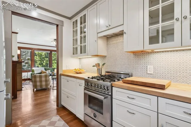 a kitchen with cabinets stainless steel appliances and wooden floor