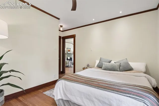 a bedroom with a bed and a potted plant on the dresser
