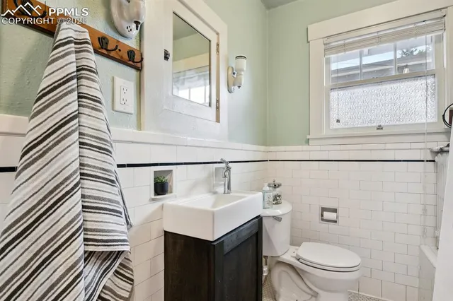 a bathroom with a sink a toilet and mirror