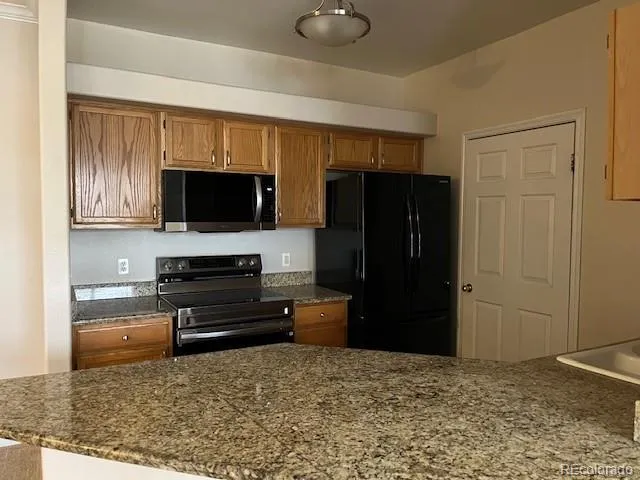 a view of kitchen with refrigerator cabinets and furniture