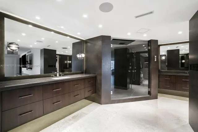 a large bathroom with a large mirror vanity and shower