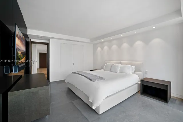 a bedroom with a bed and a flat screen tv