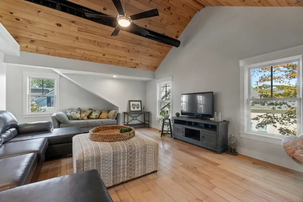 a view of a living room and a dining table with wooden floor