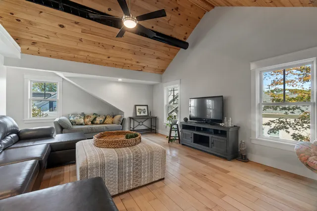 a view of a living room and a dining table with wooden floor