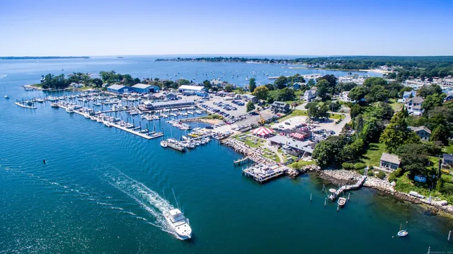 a kitchen with stainless steel appliances kitchen island granite countertop a stove a sink a dining table and chairs with wooden floor