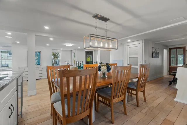 a dining room with furniture a chandelier and wooden floor