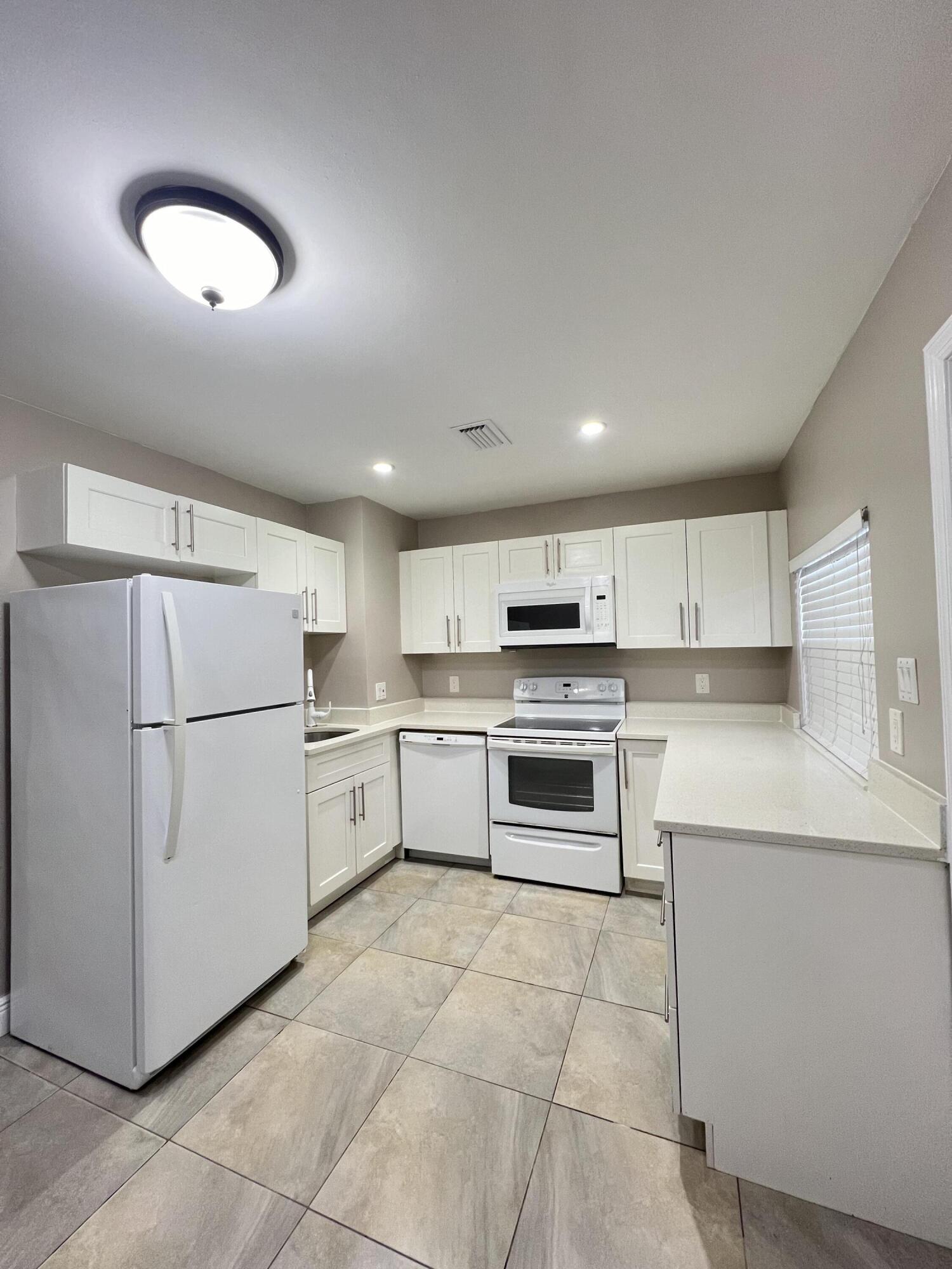 508 57th Street, Unit 3 West Palm Beach, FL 33407 - Photo 7 of 23 a kitchen with a refrigerator sink and oven