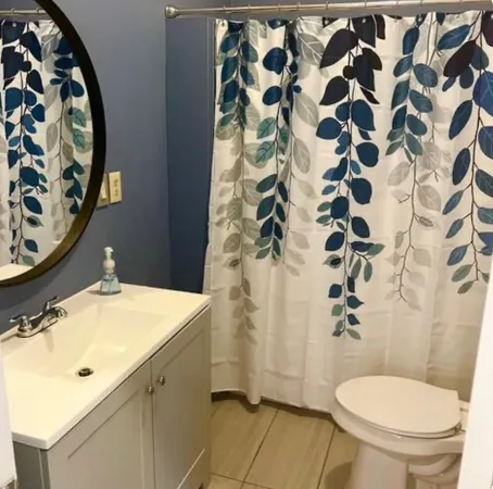 a bathroom with a sink and mirror with toilet