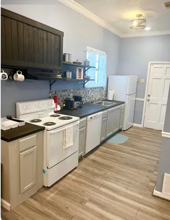 a kitchen with a sink cabinets and wooden floor