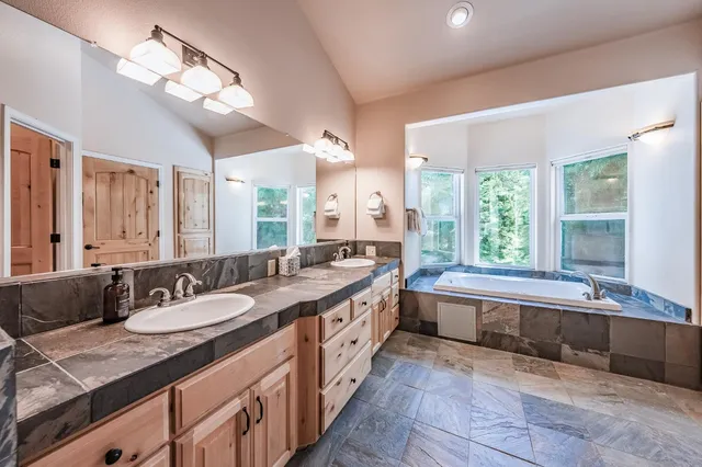 a bathroom with a granite countertop sink toilet and shower