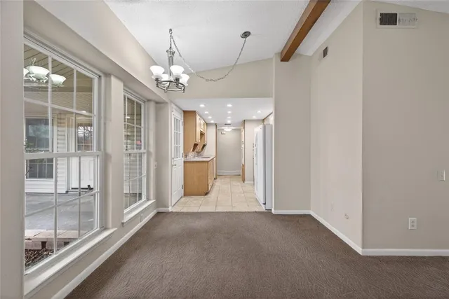 a view of a hallway with wooden floor and a kitchen