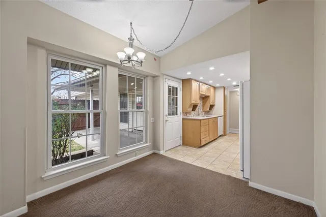 a view of a big room with windows and chandelier
