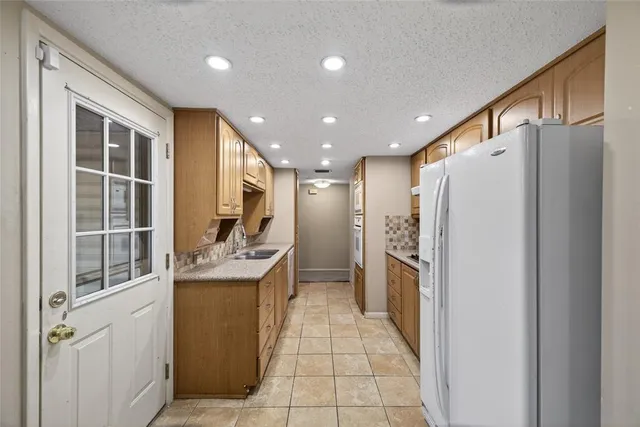 a kitchen with stainless steel appliances granite countertop a refrigerator and a stove top oven
