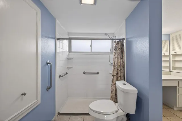 a bathroom with a toilet and a shower