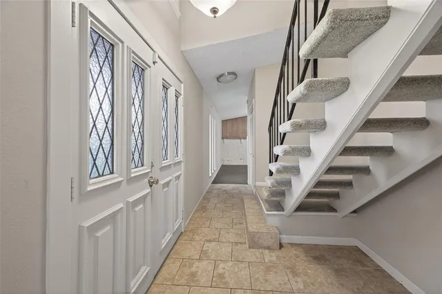 a view of staircase with lots of frames on wall and a window