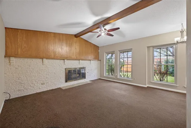 a view of an empty room with a fireplace and a window