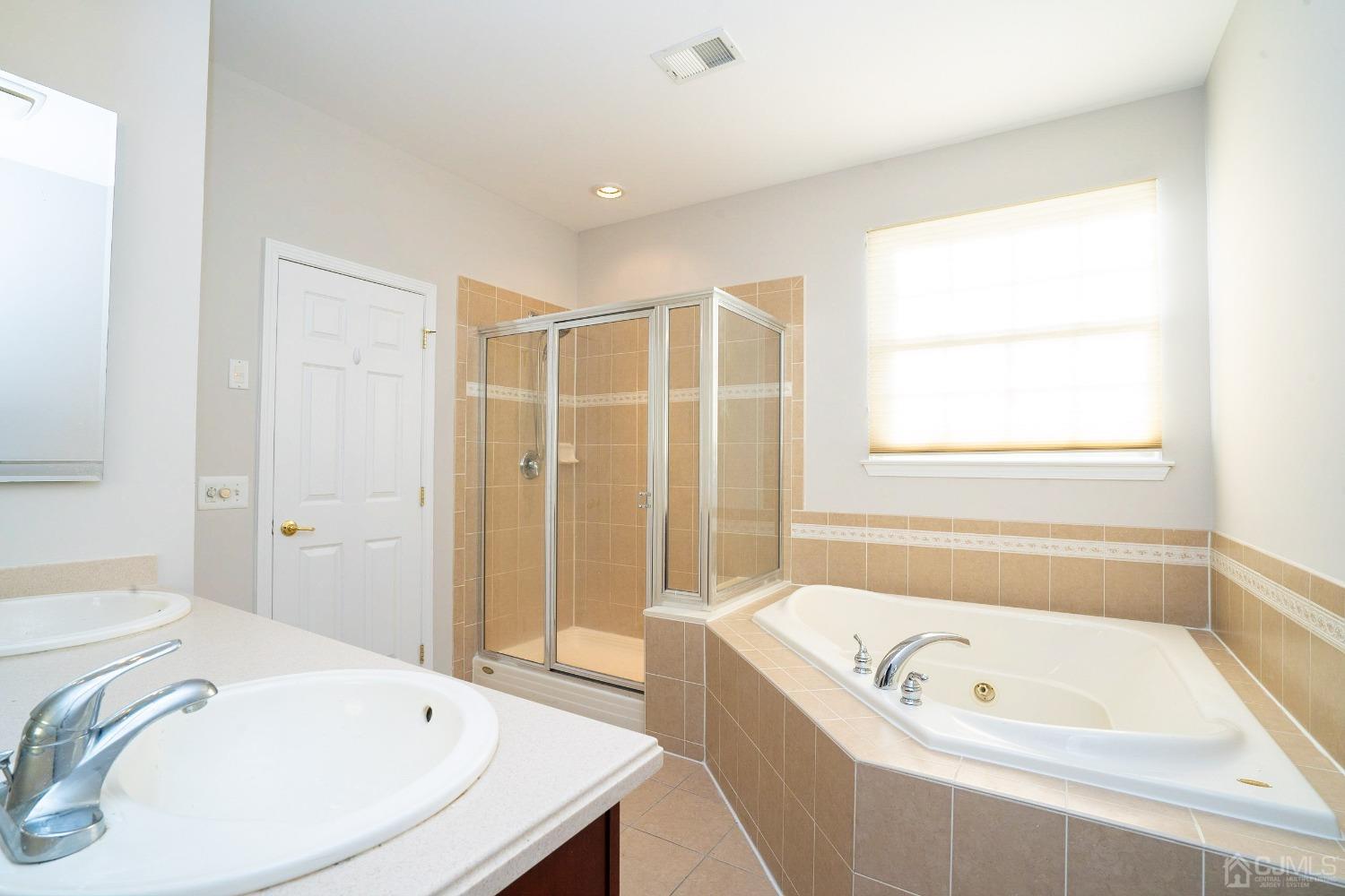 7 Stony Path Dayton, NJ 08810 - Photo 19 of 33 a bathroom with a tub a sink and a window