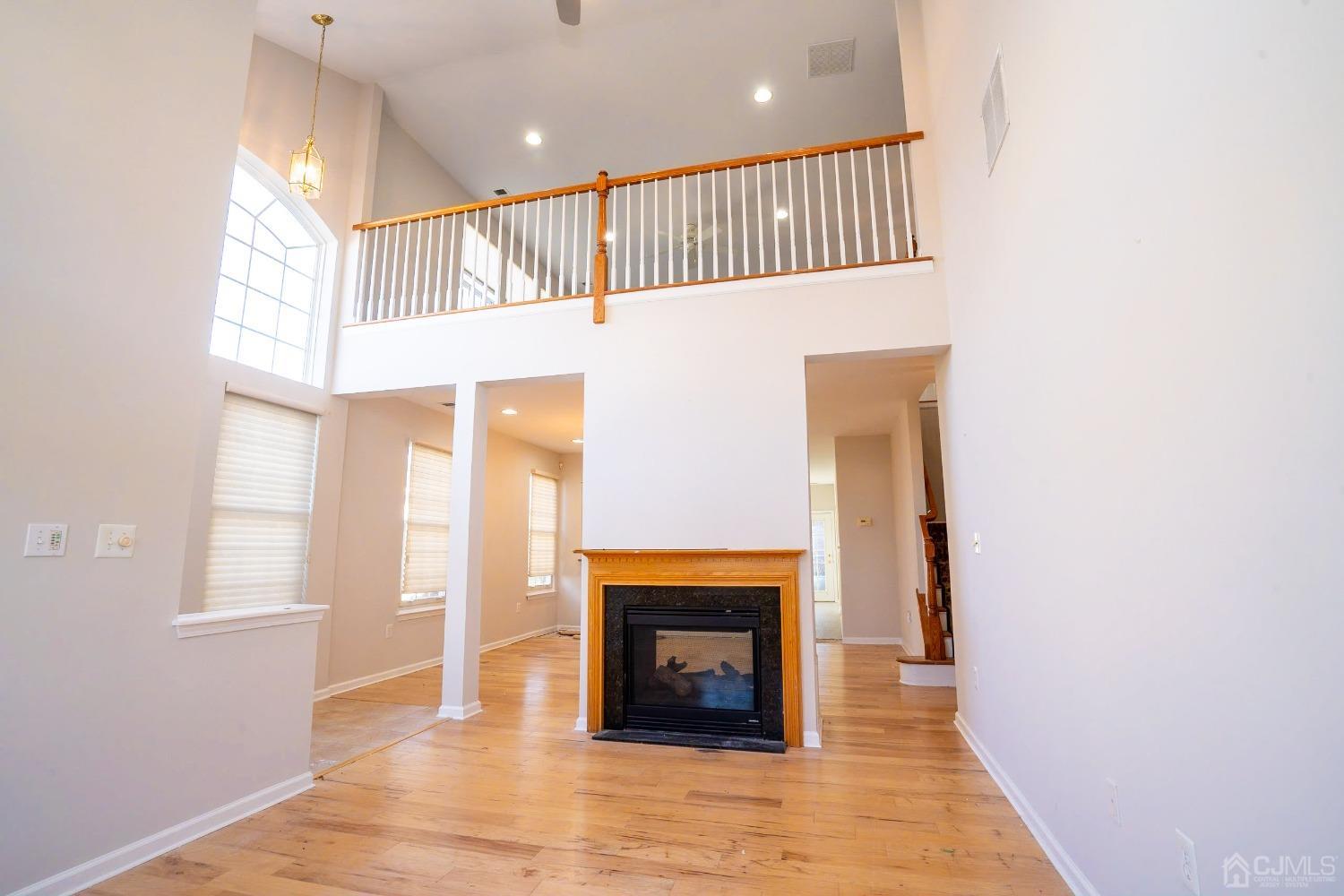 7 Stony Path Dayton, NJ 08810 - Photo 6 of 33 a view of an empty room with wooden floor fireplace and a window