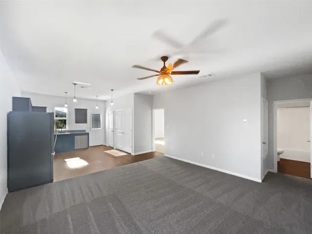 a view of a livingroom with a ceiling fan and window