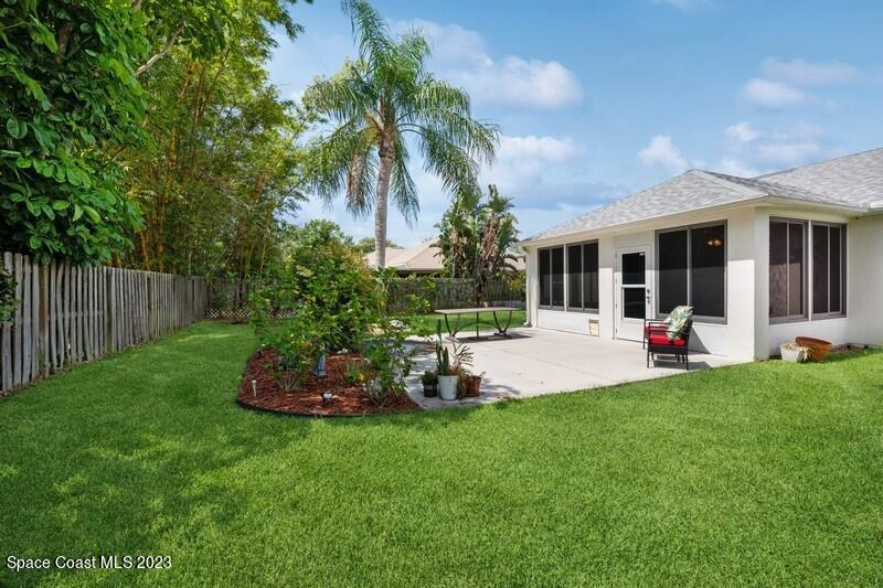 1102 Sunday Drive Rockledge, FL 32955 - Photo 13 of 16 a view of a backyard with table and chairs potted plants and palm tree