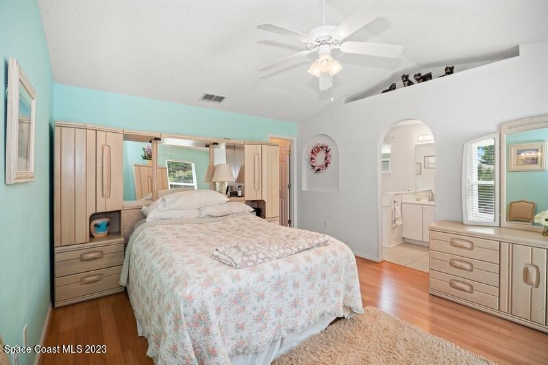 1102 Sunday Drive Rockledge, FL 32955 - Photo 6 of 16 a spacious bedroom with a bed a dresser and a chandelier
