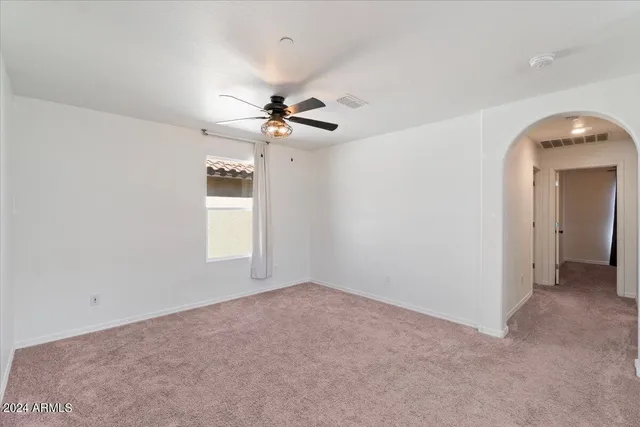 a view of a livingroom with a ceiling fan and window