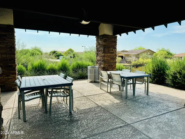 a view of a patio with a table chairs and a floor to ceiling window