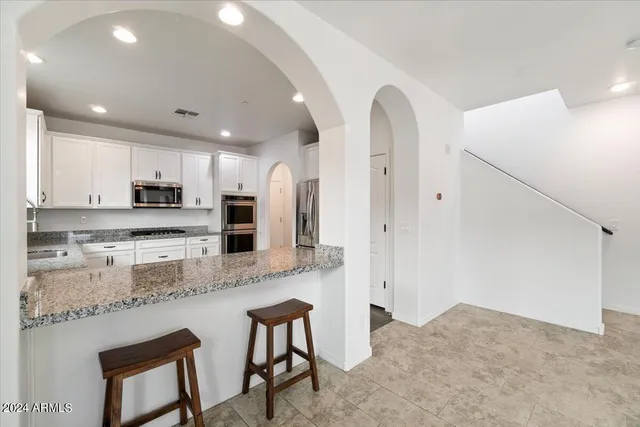 a kitchen with stainless steel appliances granite countertop a stove refrigerator sink and cabinets