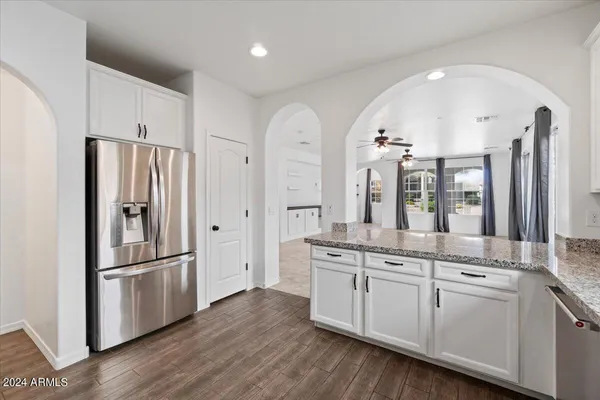 a modern kitchen with stainless steel appliances granite countertop a refrigerator and a stove top oven