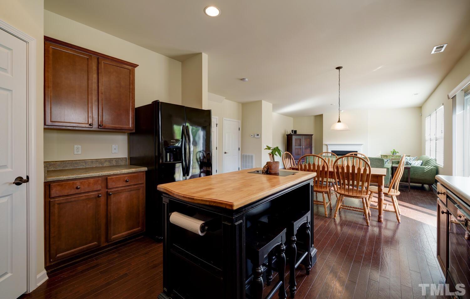 4104 Burnaby Street Raleigh, NC 27616 - Photo 11 of 59 a kitchen with stainless steel appliances granite countertop a table chairs and a refrigerator