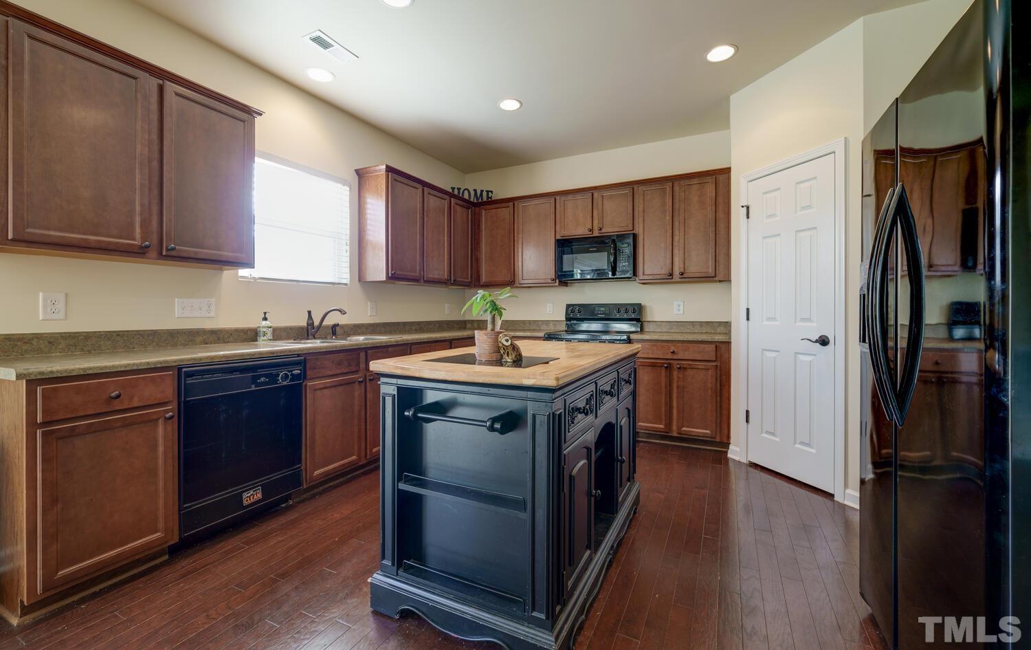 4104 Burnaby Street Raleigh, NC 27616 - Photo 12 of 59 a kitchen with a sink stove and refrigerator