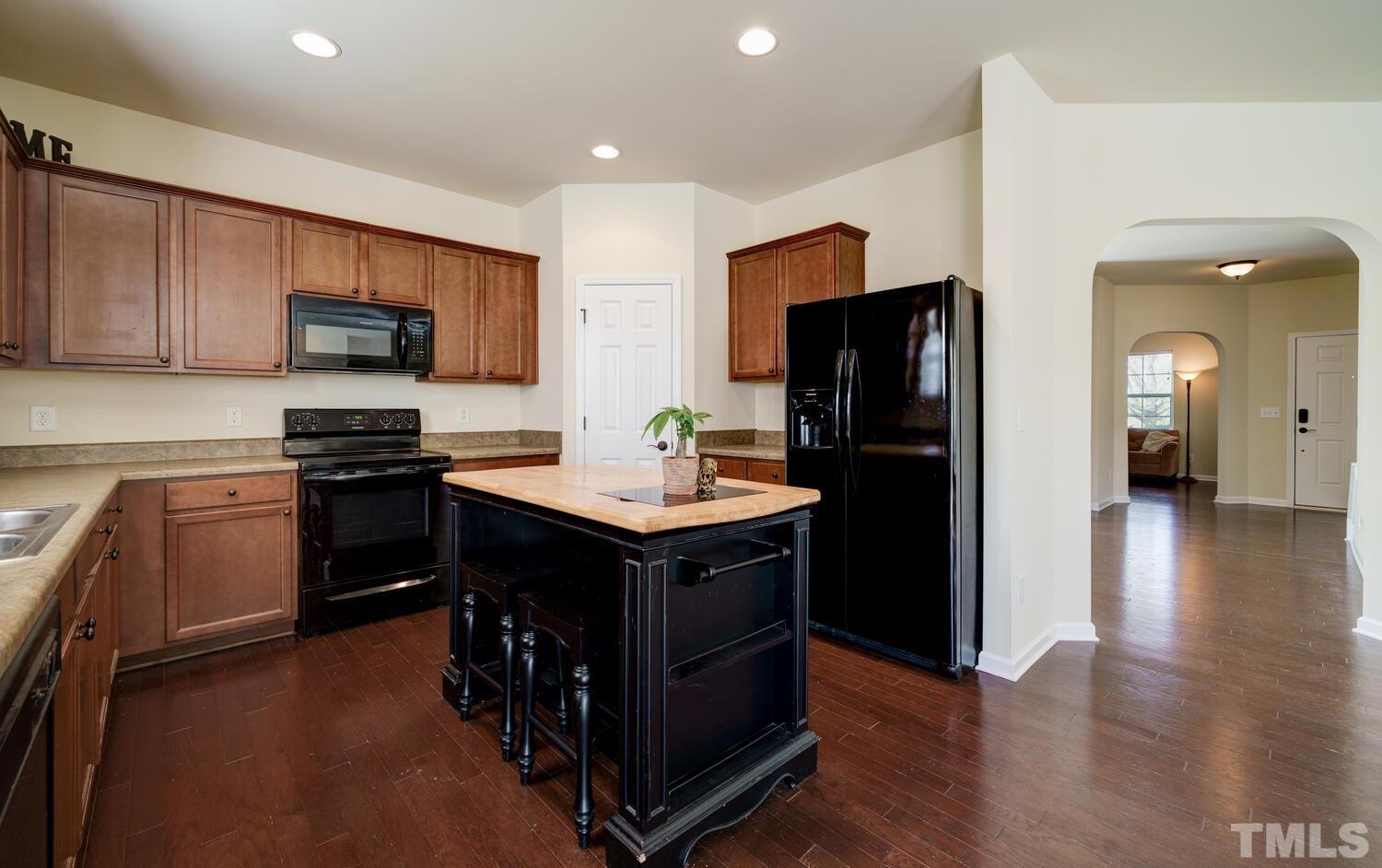 4104 Burnaby Street Raleigh, NC 27616 - Photo 14 of 59 a kitchen with a refrigerator and a stove top oven
