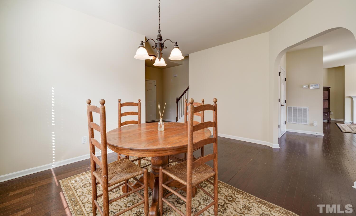 4104 Burnaby Street Raleigh, NC 27616 - Photo 18 of 59 a dining room with furniture a chandelier and wooden floor