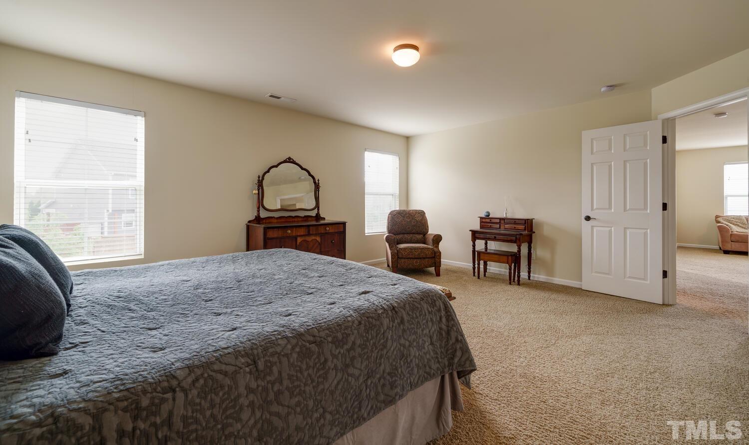4104 Burnaby Street Raleigh, NC 27616 - Photo 21 of 59 a bedroom with a bed and dresser with mirror