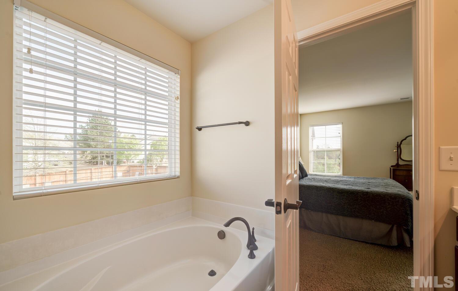 4104 Burnaby Street Raleigh, NC 27616 - Photo 23 of 59 a bathroom with a bathtub and a window