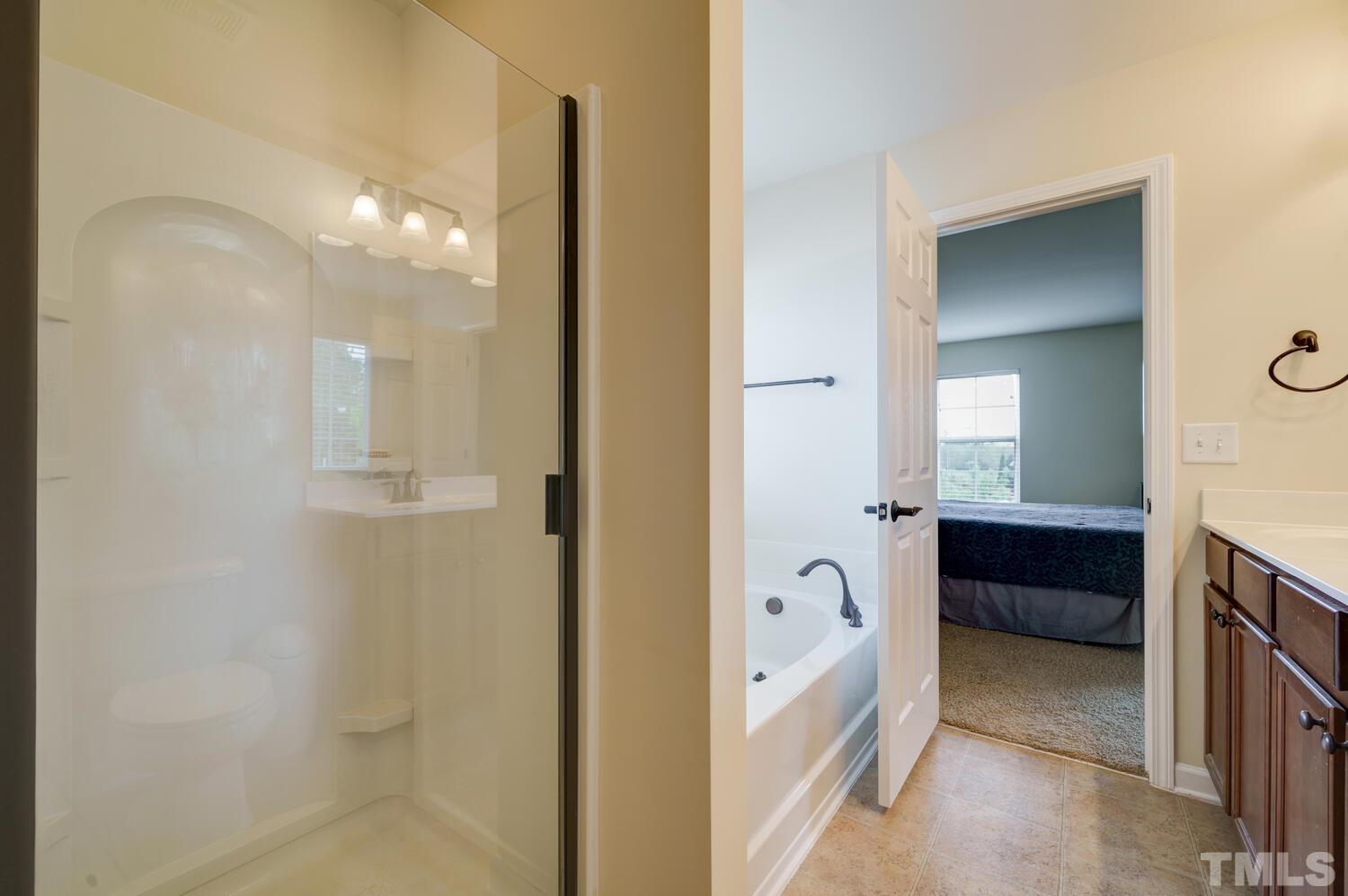 4104 Burnaby Street Raleigh, NC 27616 - Photo 25 of 59 a bathroom with a tub shower and a sink
